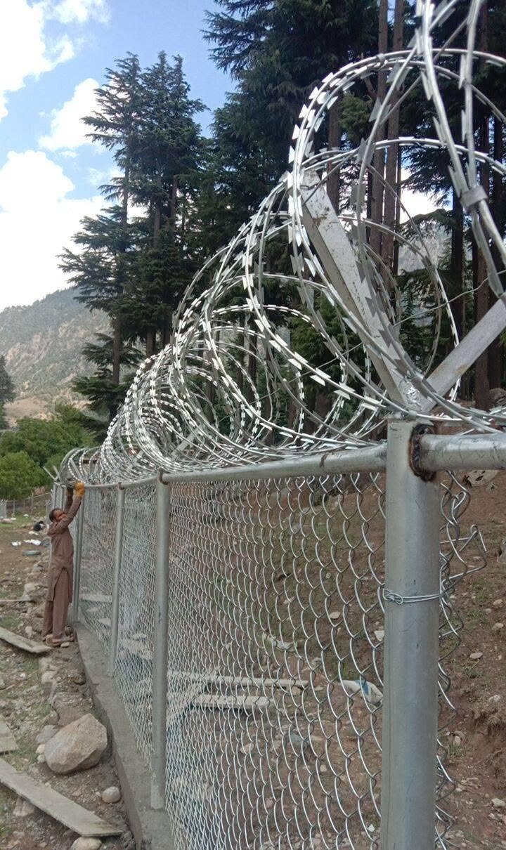 Kalam / Swat hill-area chain link with razor wire supporting photo